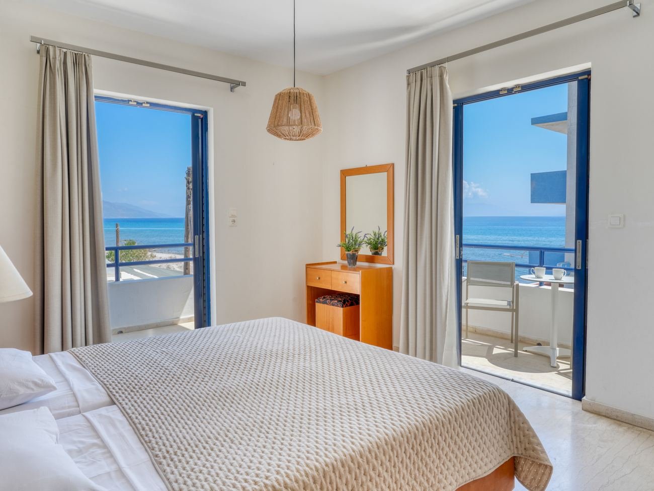 Sea view studio bedroom at Philippos — blue balcony doors opening to the Aegean